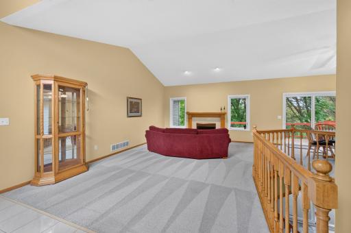 Main floor Great room with vaulted ceiling, gas fireplace with tile facing and custom oak surround and recessed accent lighting.