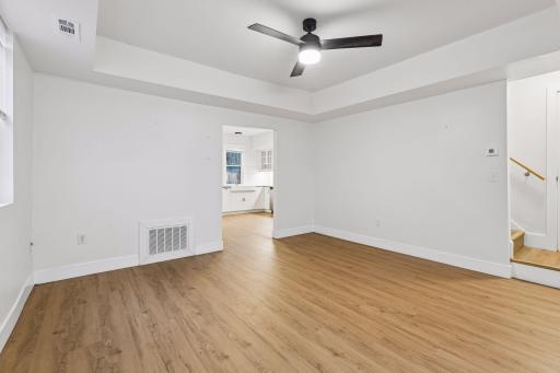 Unit 1: Spacious living room featuring ceiling fan with light, updated flooring and windows for great natural light.