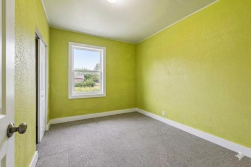 Unit 2: A bright and comfortable main-floor bedroom with carpet, overhead light, and a double closet for extra storage.