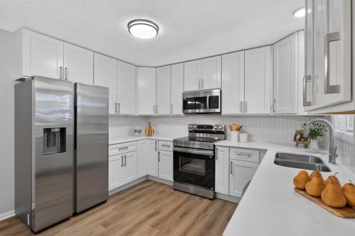 Main level: brand new kitchen cabinets, quartz counters, backsplash, stainless appliances, and LPV