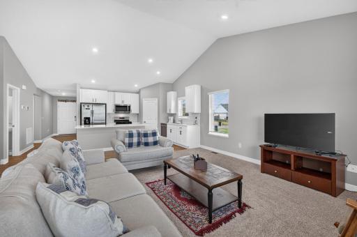 Step inside to a bright and welcoming open-concept layout featuring vaulted ceilings, abundant natural light, and beautiful neutral finishes. The spacious living area flows seamlessly into the kitchen and dining spaces, creating the perfect setting f