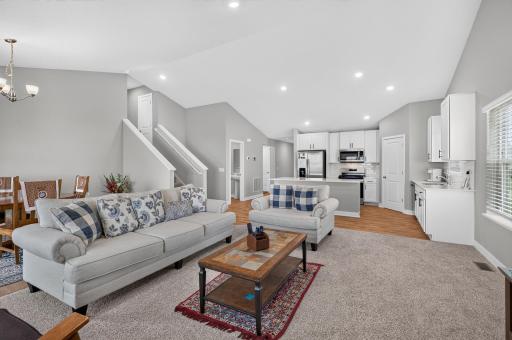 The open-concept design makes entertaining effortless, with the kitchen overlooking the spacious living room. Vaulted ceilings, recessed lighting, and neutral finishes create an airy, inviting atmosphere with plenty of room to gather.