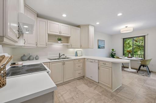 Kitchen conveniently opens to the remodeled deck with newer Andersen patio door, new railings in 2025 and Trex decking in 2020.