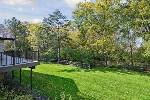 Remodeled deck overlooks privacy with mature landscaping and HOA maintained lawn.