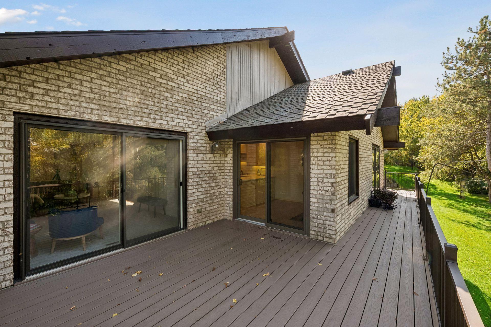 Three patio doors provide natural light and accessibility to the wraparound deck. Newer Andersen patio door opens into the kitchen.
