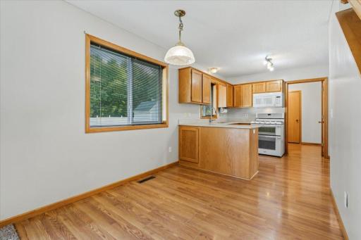 Informal dining room off of kitchen area. Frigerator and cabinets to the right.