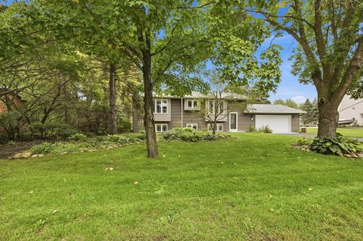 The exterior has been refreshed with vinyl siding, architectural shingles, seamless rain gutters with leaf guards, an updated front door with Andersen storm door, and updated exterior lighting and house numbers.
