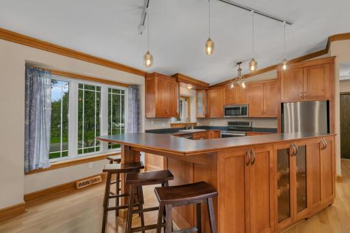 The large island provides generous workspace along with dual electrical outlets, cabinet storage, drawers, and a built-in wine rack.