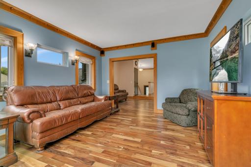 The hardwood flooring continues into the four-season sunroom, creating a warm and seamless connection between the interior living spaces and the outdoors.