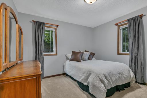 Additional storage is thoughtfully incorporated throughout the home, including a generous hallway linen closet, a convenient coat closet at the top of the stairs, and illuminated storage beneath the stairs with built-in shelving.
