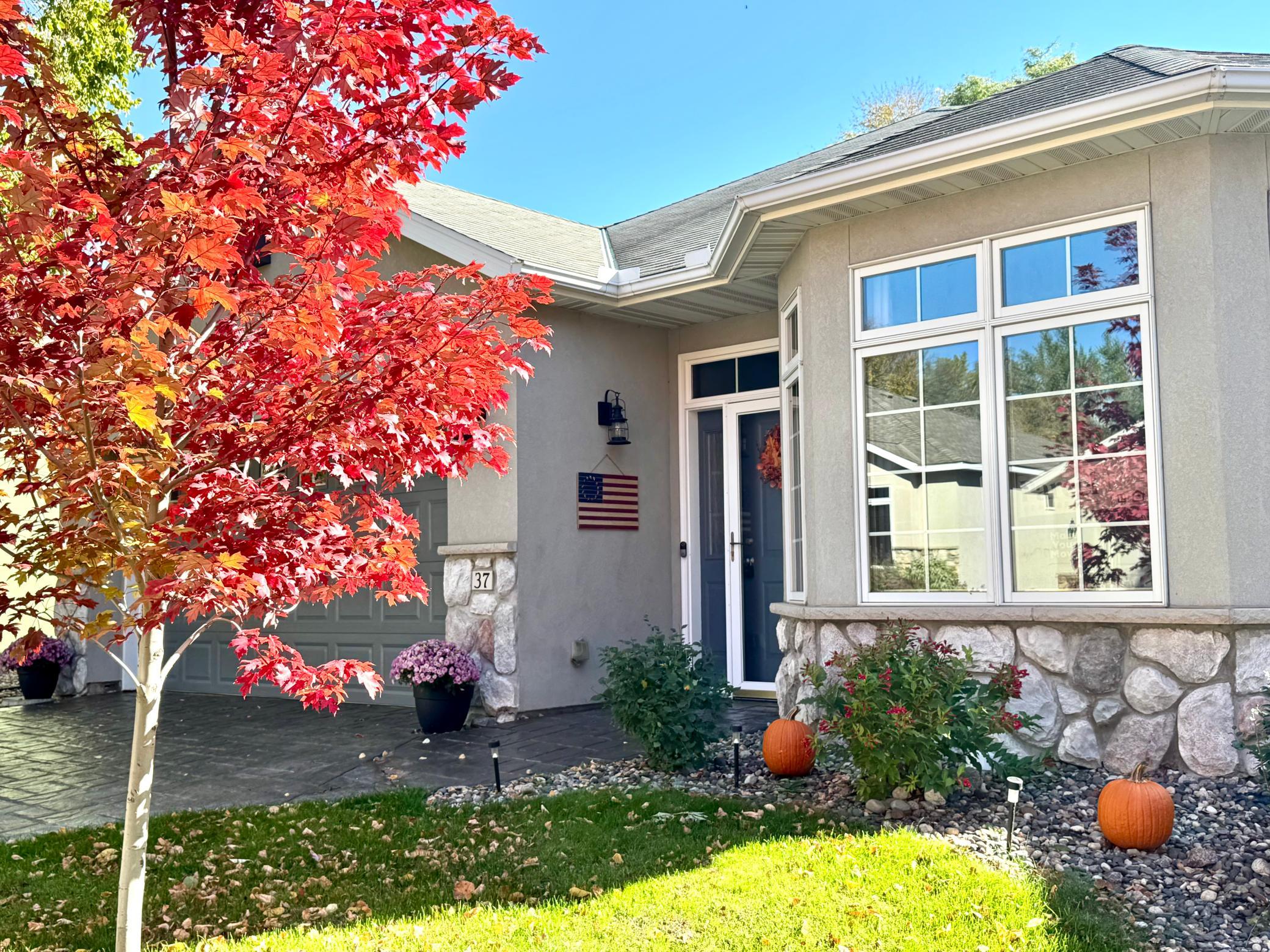 A custom stamped concrete driveway creates an inviting approach to this exceptional townhouse, where a charming bay window and standout curb appeal welcome you into effortless, one-level living!