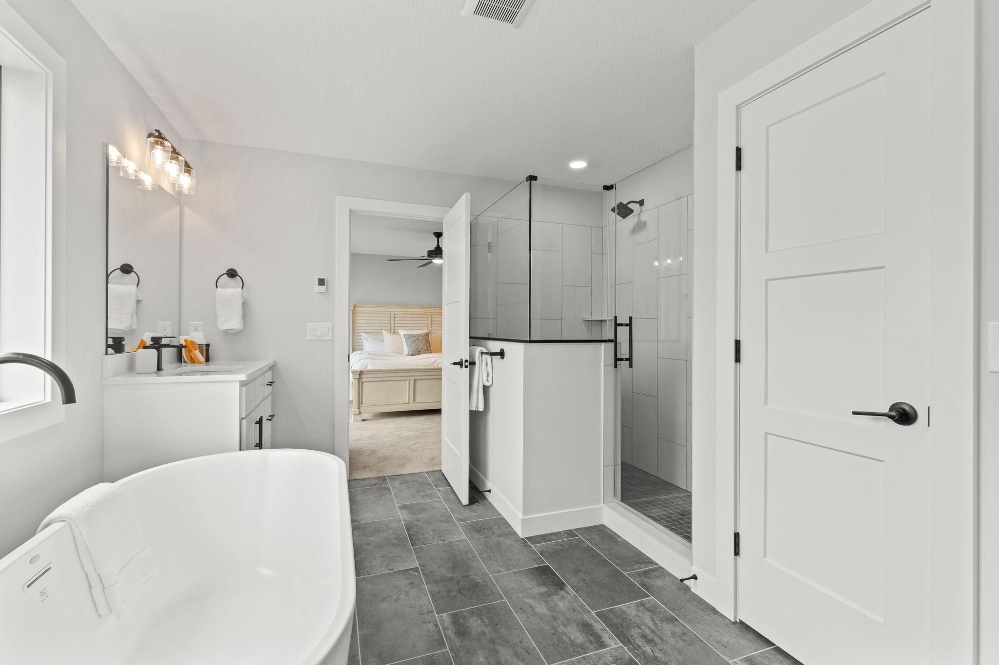Another view of the spacious, spa-like primary bathroom, showcasing its inviting design and luxurious feel.