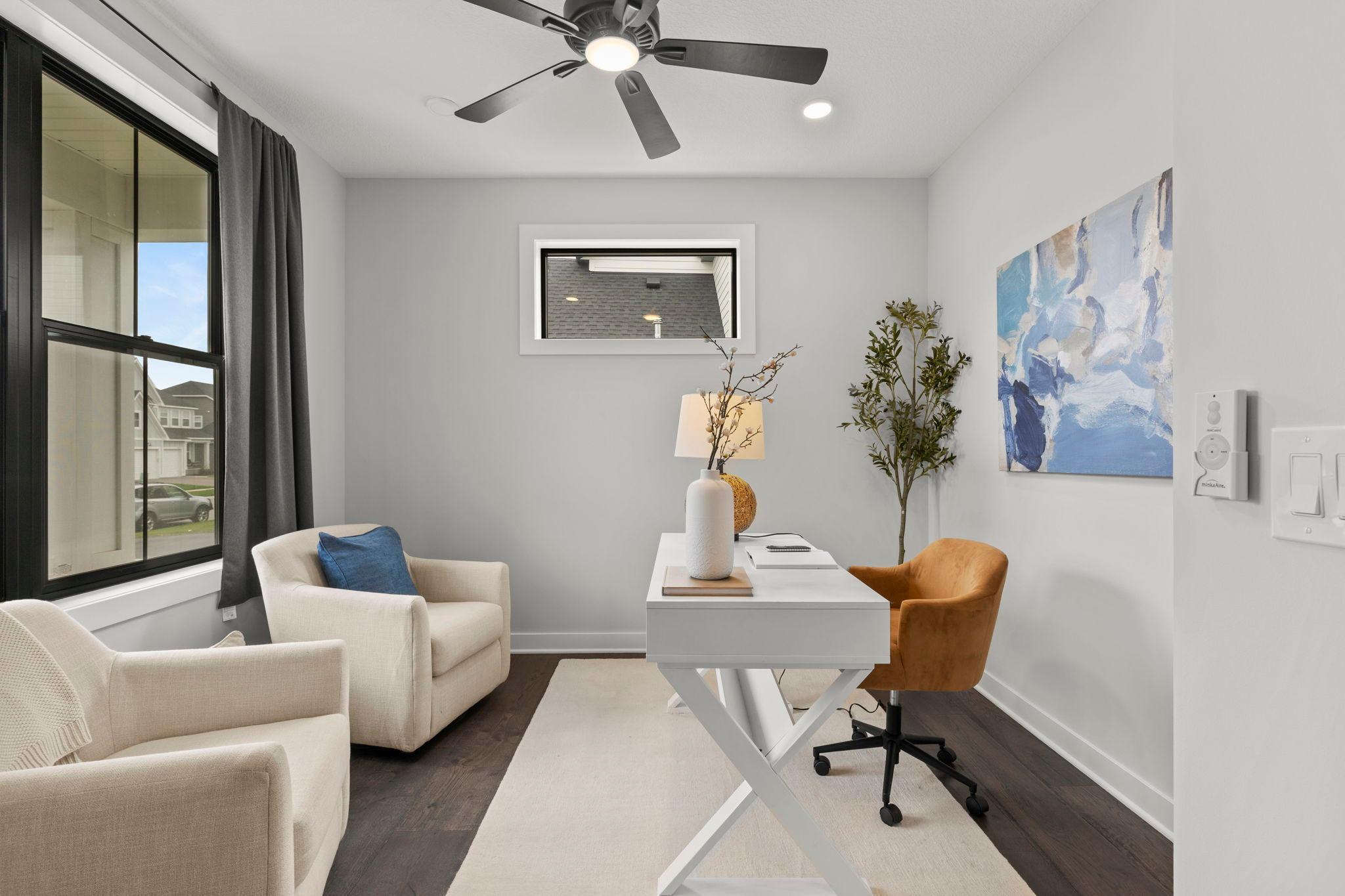Just off the foyer, the main-level office or den offers stylish sliding barn doors, a large front-facing window, and a ceiling fan—an ideal space for working from home or creating a quiet retreat.