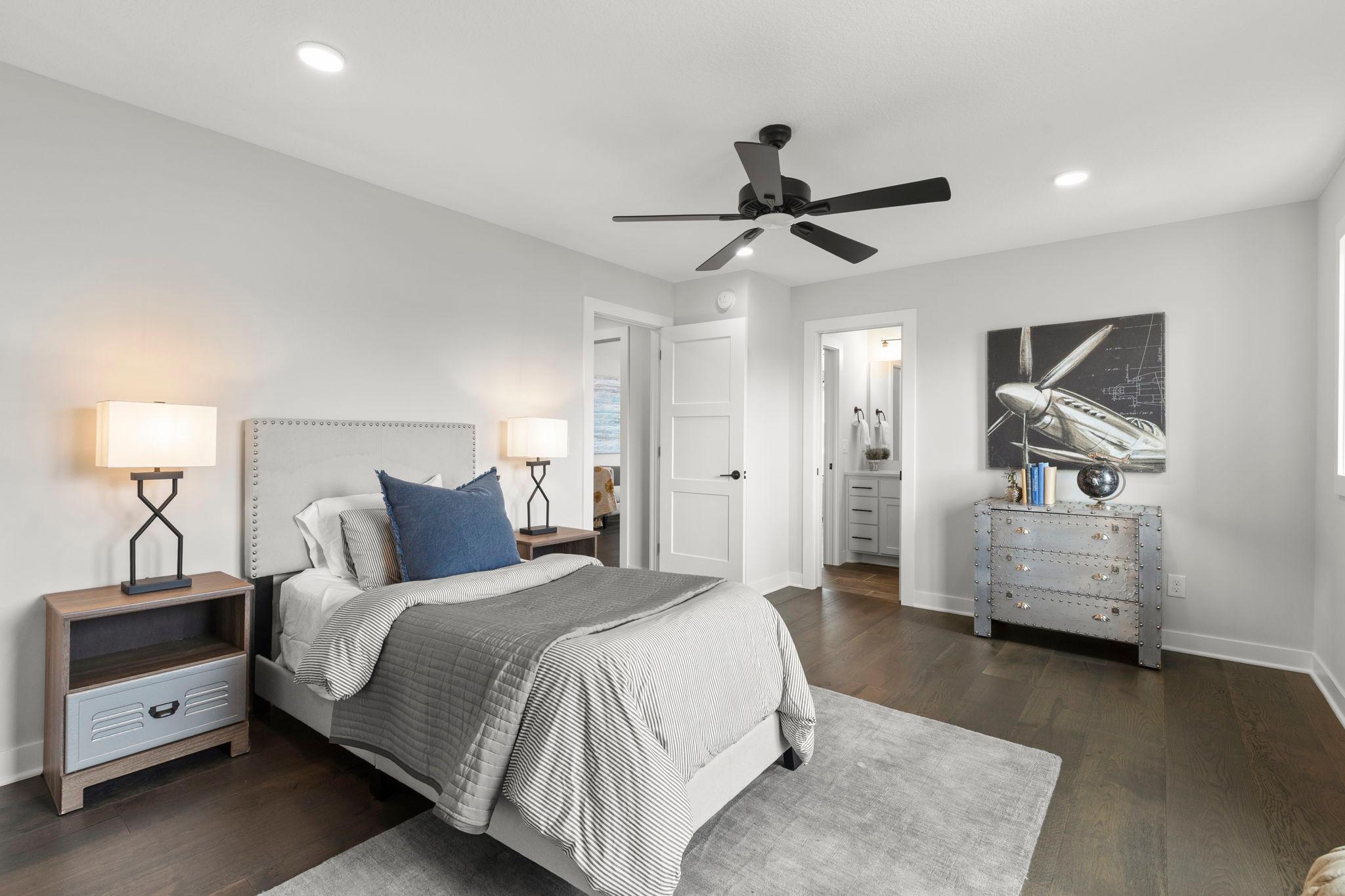 Bedroom four is generously sized and features beautiful hardwood flooring, a front-facing window, spacious walk-in closet, ceiling fan, and access to a walkthrough ¾ bathroom.