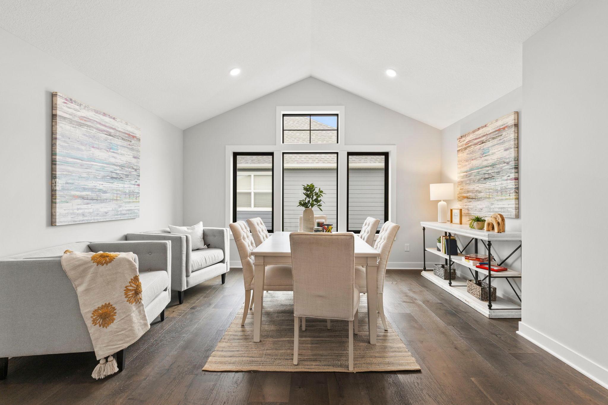 An impressive upper-level bonus room features double-door entry, 10-foot vaulted ceilings, hardwood flooring, and large side-facing windows.