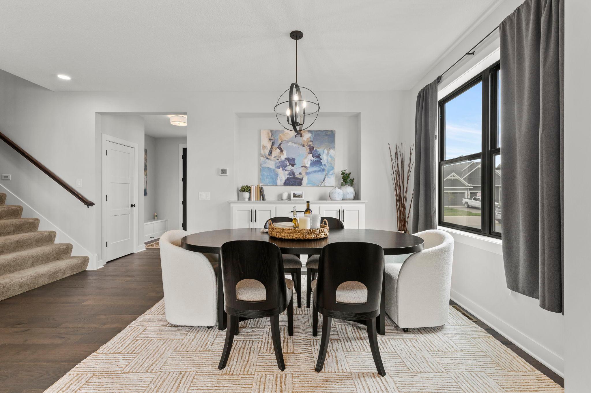 The formal dining room offers a built-in buffet with quartz countertops and cabinetry, along with a large side window that fills the space with natural light.