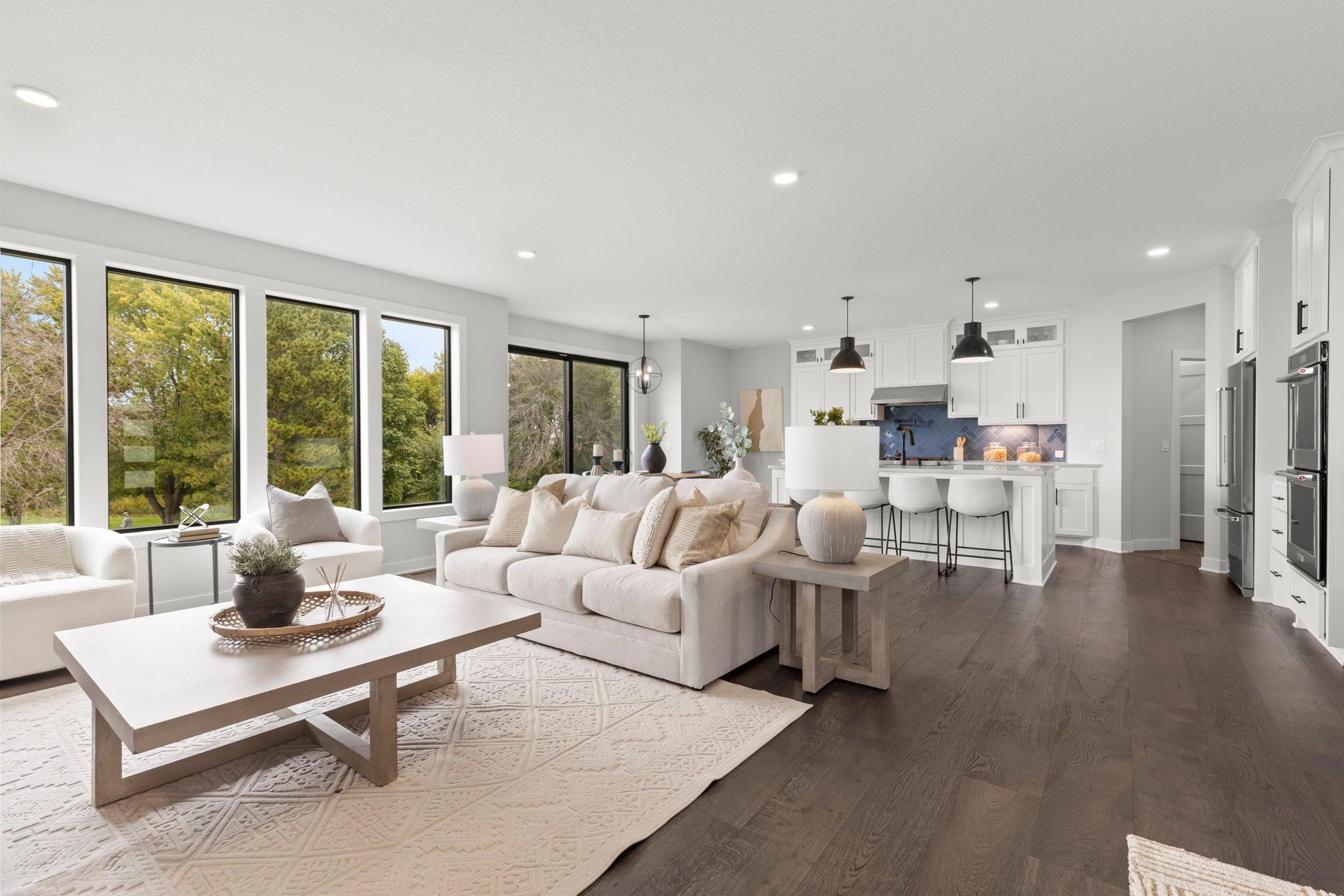Large windows overlook the peaceful backyard, filling the living room with natural light.