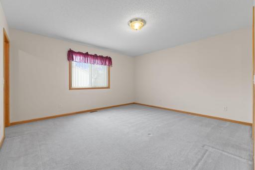 The spacious primary suite provides a comfortable and private retreat, featuring a large walk-in closet and convenient pass-through bath access. With plenty of room for furnishings and abundant natural light.