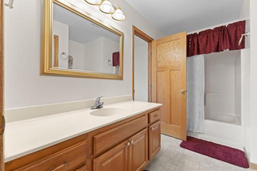 The main-level full bath features convenient pass-through access from the primary suite. Thoughtfully designed for everyday living, it provides easy access from the primary bedroom while remaining accessible to guests and the rest of the home.