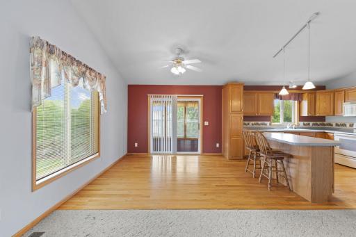 From the living room, you'll enjoy an inviting view into the charming 3-season porch, where warm knotty pine accents and abundant natural light create a seamless connection between the home's interior and the peaceful backyard setting.