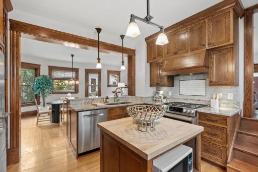 Updated kitchen with wood cabinetry, granite counters and butcher-block island
