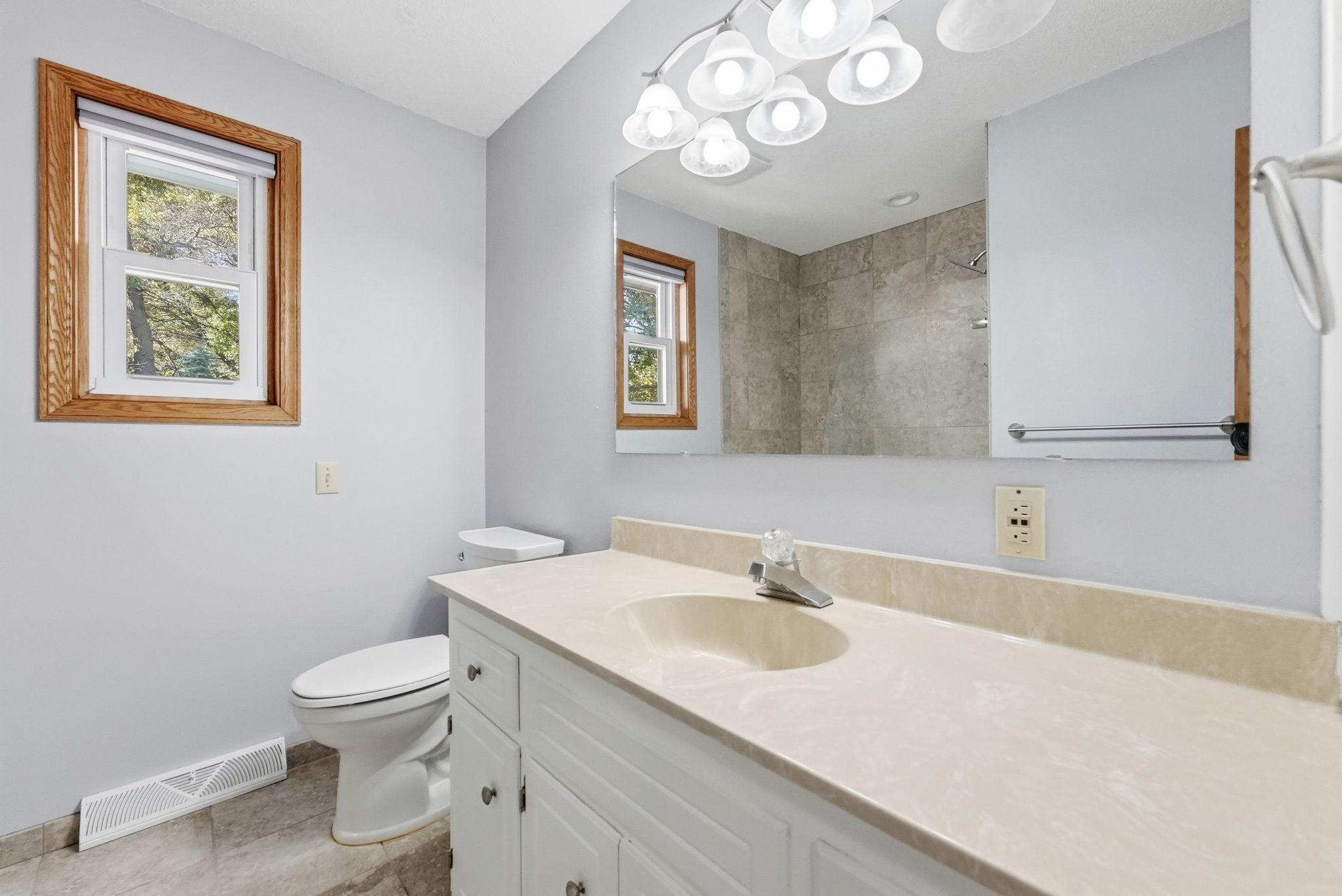 Full, shared, upper level bathroom with a large vanity.