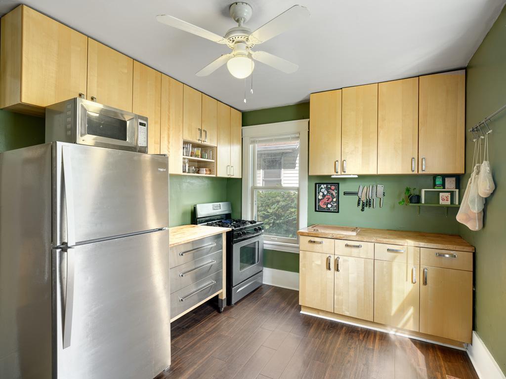 Quaint kitchen featuring newer luxury vinyl plank flooring, stainless steel appliances, a gas range, and ample cabinet storage. There's even room for a charming pub-style table to create the perfect casual dining space.