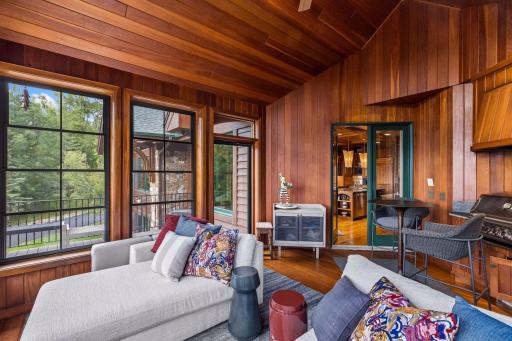 Year-round grilling and entertaining: this three-season porch features an indoor gas grill, vaulted wood ceiling, and direct access to the outdoor deck