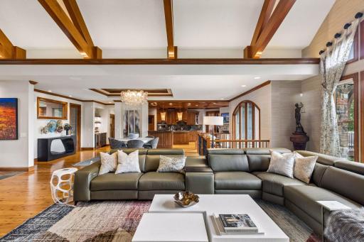 Vaulted beams and warm hardwoods unite the living, dining, and kitchen in one light-filled great room