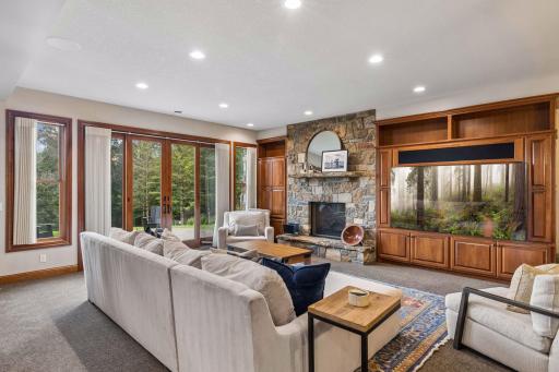 Cozy lower level family room with stone fireplace and French doors opening to St. Croix Valley views