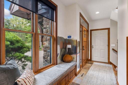 Side entry with a built-in window seat, slate floors, and a designer accent wall, a stylish spot to drop your things