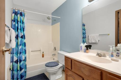 Full dual-entry bathroom featuring updated rain showerheads and convenient access from both adjoining spaces.
