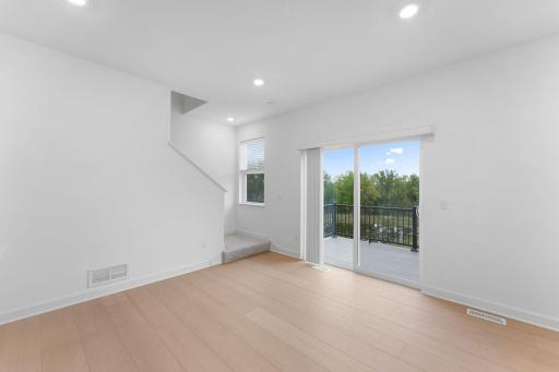 Natural light streams in from glass sliders onto the dining area, setting the scene for daily meals with family and friends.