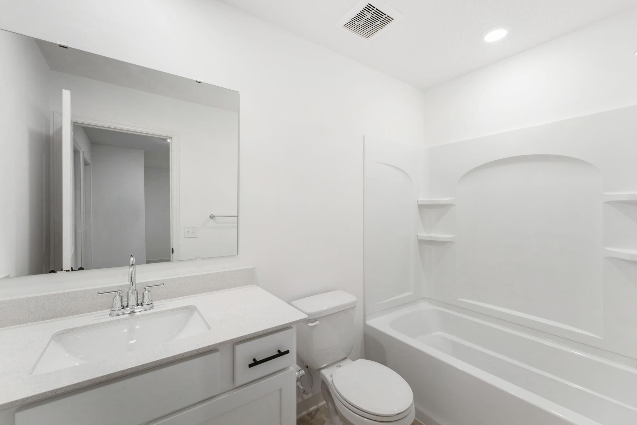 A full bathroom on the second floor comes well-equipped with a stylish vanity and a combination shower and tub.