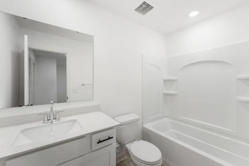 A full bathroom on the second floor comes well-equipped with a stylish vanity and a combination shower and tub.