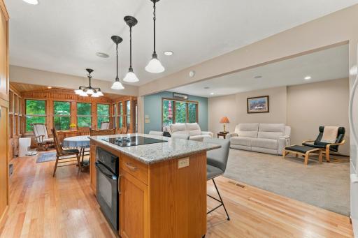 A wall was removed between the living room and kitchen to open up the space. Notice the gorgeous oak hardwood flooring throughout the kitchen, dining, and 4-season porch.