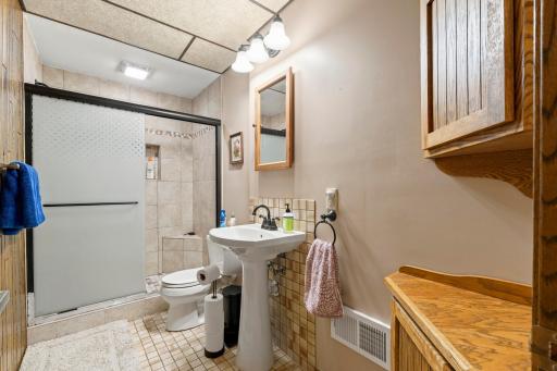 Lower-level three-quarter bath with tiled shower.
