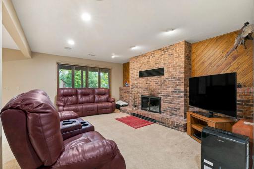 Lower-level family room with a beautiful brick wood-burning fireplace. Family room has lots of recessed lighting. All popcorn ceilings in the home have been removed and replaced with knockdown ceilings.