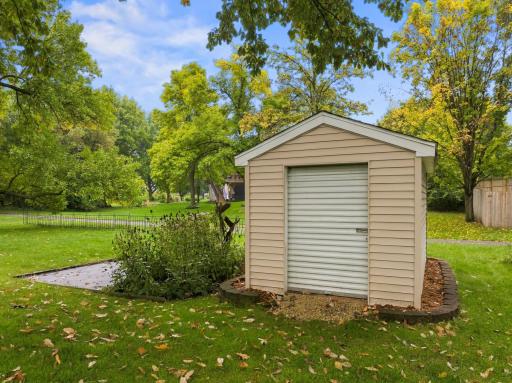Storage shed with roll up door for lawn/garden equipment.