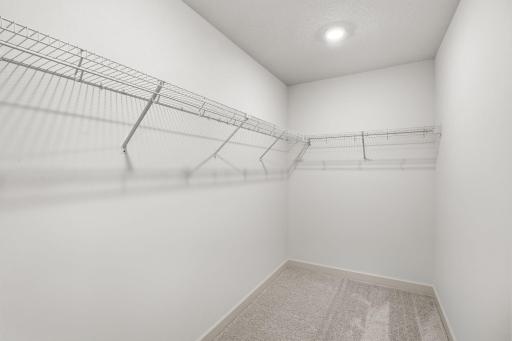 The walk-in closet with built-in shelving provides ample room for growing wardrobes