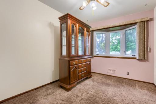 Formal Dining room with bay window towards the backyard. China Hutch does not stay. Hardwood floors under the carpet and closet for extra storage.