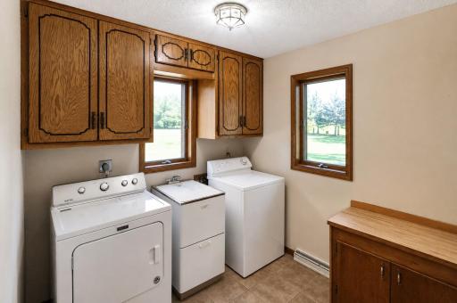 Main floor laundry room with sink and storage