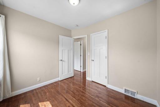The second main level bedroom blends timeless character with thoughtful updates. Original hardwood floors add warmth and charm, while fresh paint, upgraded doors, and a nice sized closet create a space that feels clean and comfortable.