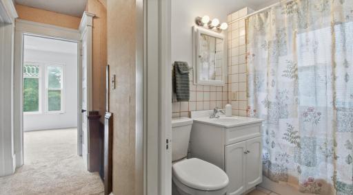 Full bath with surrounding tile, on the upper level.