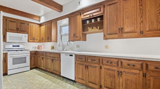 The kitchen with its ample cabinetry and new gas range, microwave, and dishwasher (2025).