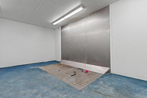 Specialized processing room featuring stainless-steel wall protection and large grated floor drainage area