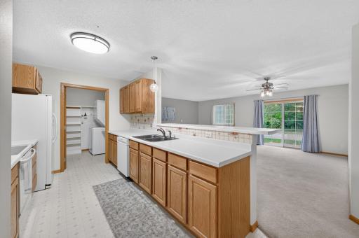 Spacious kitchen with abundant cabinetry and counter space, opening to the bright living area with patio access.