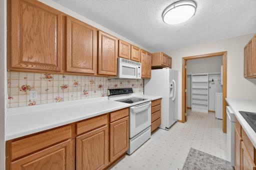 Bright, functional kitchen featuring ample cabinetry, generous counter space and an adjoining laundry area.