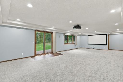 Lower level family room with walk-out to patio, projector and screen, in wall speakers