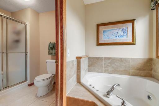 Relax and unwind in the primary bath featuring a jetted tub and separate shower.